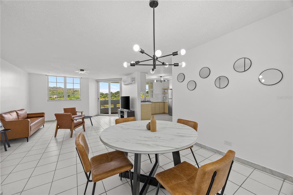 A dining area with a round table and chairs sits in front of a living room — VIA PEDREGAL COND MONTECILLO COURT VIA PEDREGAL APT #4808 UNIT 48, TRUJILLO ALTO, PR