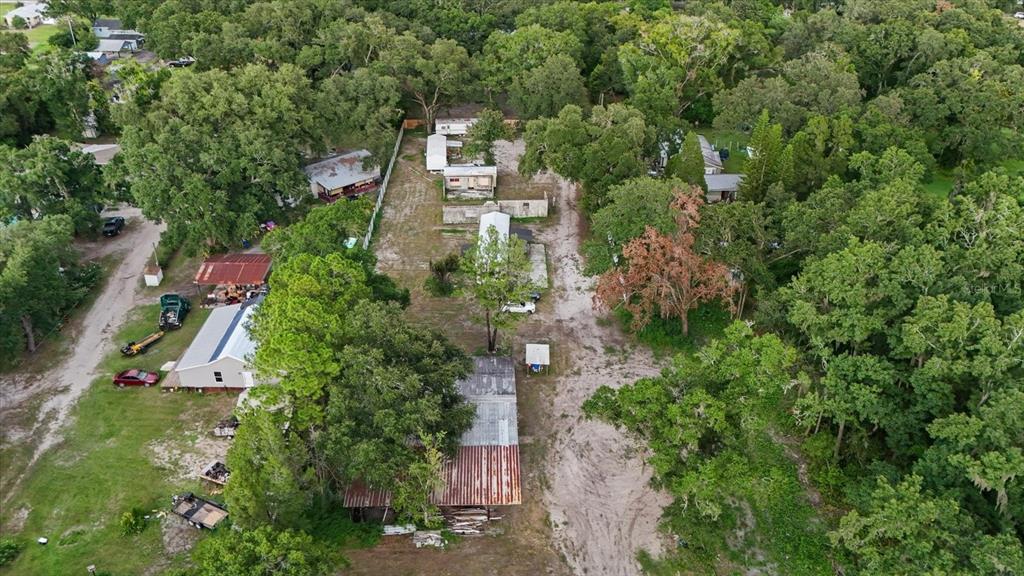 An aerial view shows several mobile homes and outbuildings situated on a wooded, sandy lot — 2102 SYDNEY DOVER ROAD, DOVER, FL