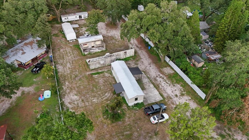 An aerial view shows a property with multiple mobile homes, a concrete structure, and vehicles — 2102 SYDNEY DOVER ROAD, DOVER, FL
