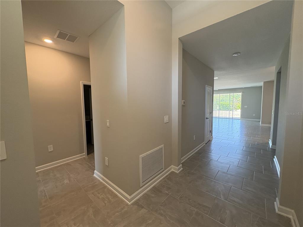 A tiled entryway leads into a bright living area with sliding glass doors — 2836 CAMDEN WAY, DAVENPORT, FL