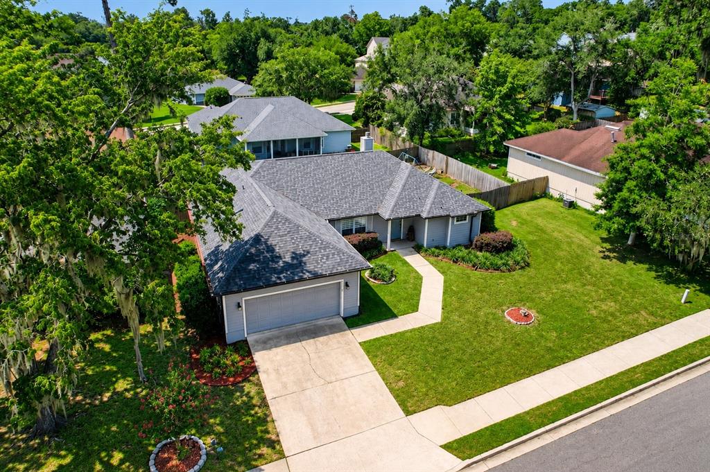 An aerial view shows a single-story house with a gray roof, garage, and front lawn — 11213 NW 34TH AVENUE, GAINESVILLE, FL