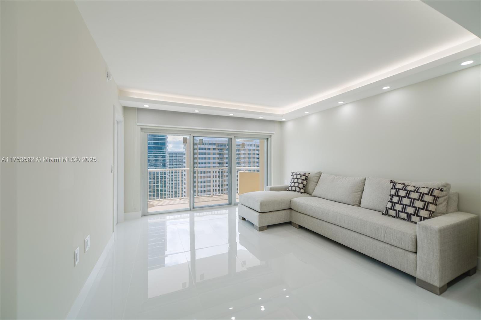 A modern living room features white tile floors, recessed lighting, and a beige sectional sofa — 1950 S Ocean Dr # 20L, Hallandale Beach FL 33009, HALLANDALE BEACH, FL