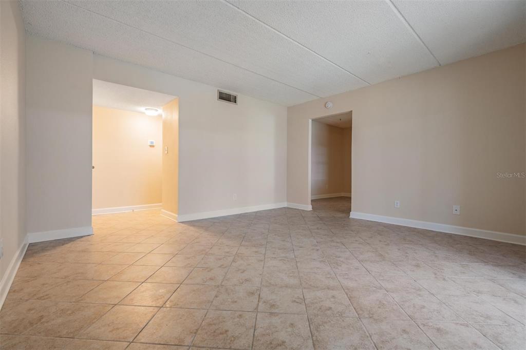 An empty room with beige tile flooring, light-colored walls, and two open doorways — 8565 12TH WAY N UNIT A, ST PETERSBURG, FL