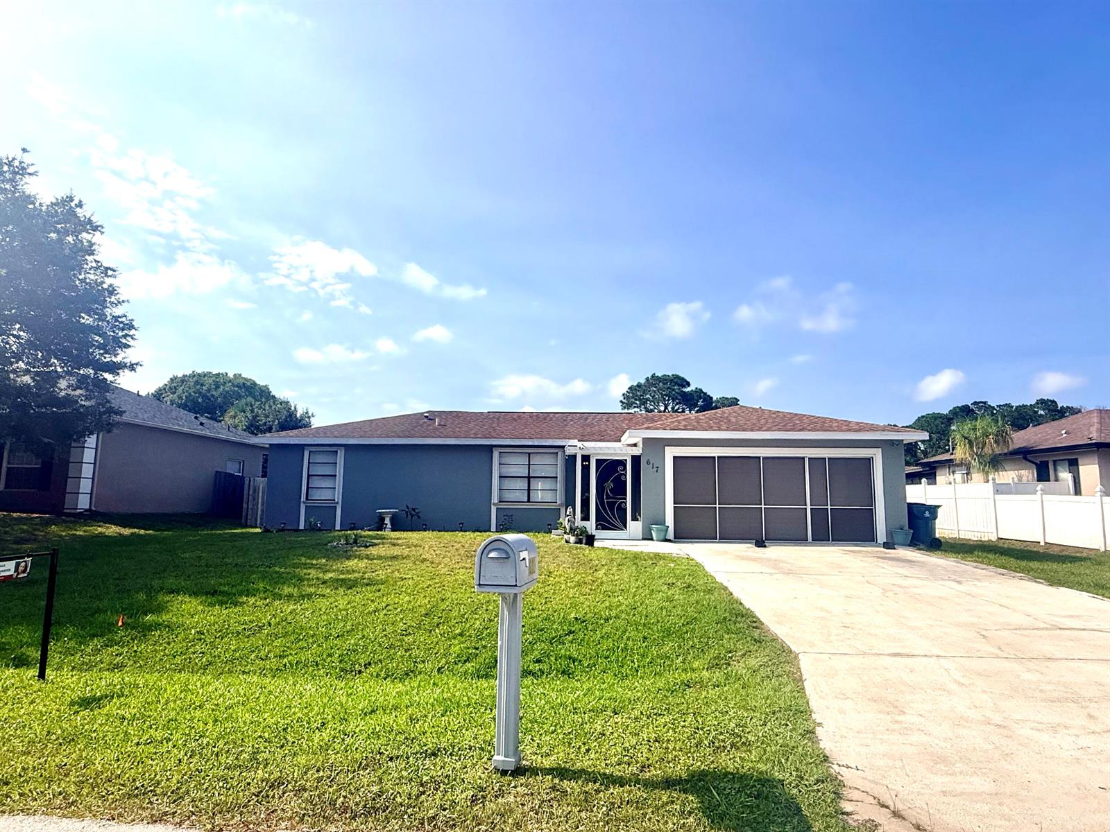 A single-story gray house with a brown roof, a concrete driveway, and a front lawn — 617 Thuringer Street NW, Palm Bay FL 32907, PALM BAY, FL