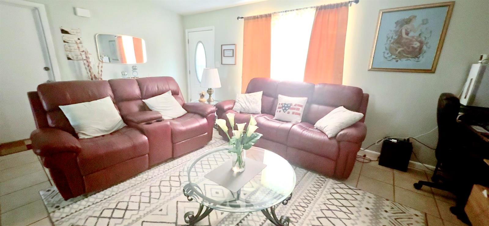A living room features two red leather sofas, a glass coffee table, and tile flooring — 617 Thuringer Street NW, Palm Bay FL 32907, PALM BAY, FL
