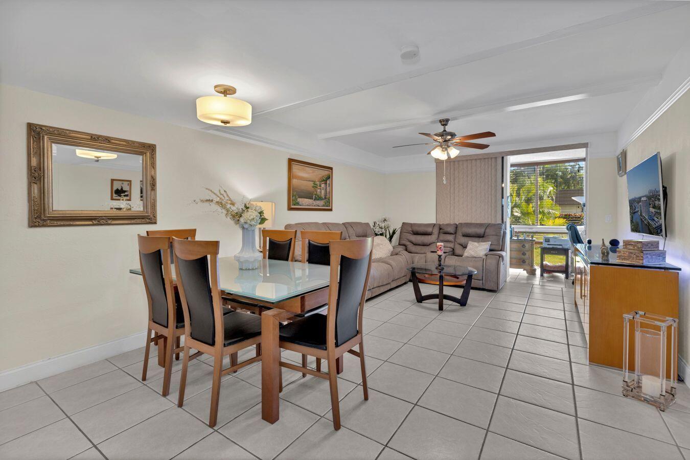 A dining area and living room with tile floors, a glass table, and a sectional sofa — 6850 Royal Palm Boulevard # 106g, Margate FL 33063, MARGATE, FL