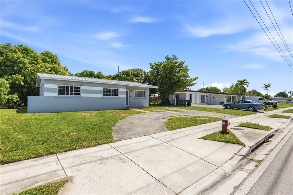 A single-story house with gray and white siding sits next to a driveway and sidewalk — 998 W 68TH STREET, HIALEAH, FL