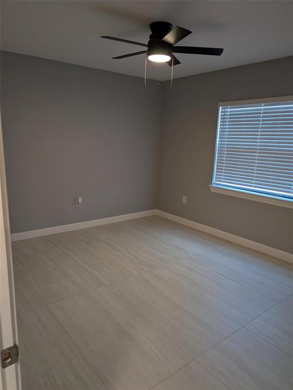 An empty bedroom features gray walls, light-colored tile flooring, and a black ceiling fan — 4416 N CLARK AVENUE UNIT 4, TAMPA, FL