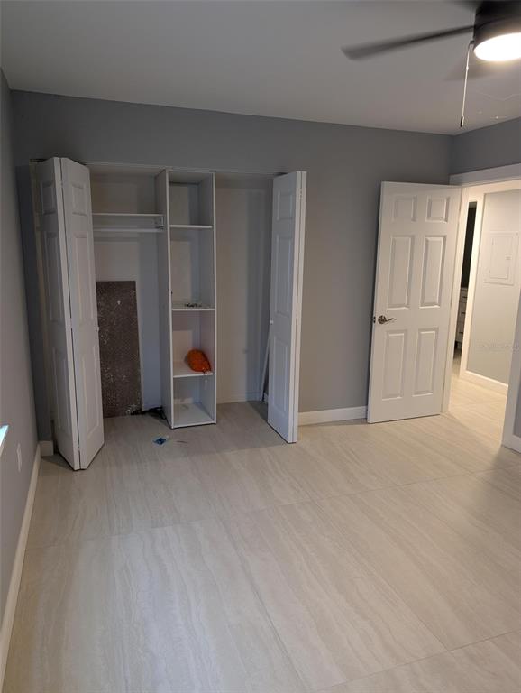 A bedroom features light-colored tile flooring, gray walls, a built-in closet unit, and white doors — 4416 N CLARK AVENUE UNIT 4, TAMPA, FL