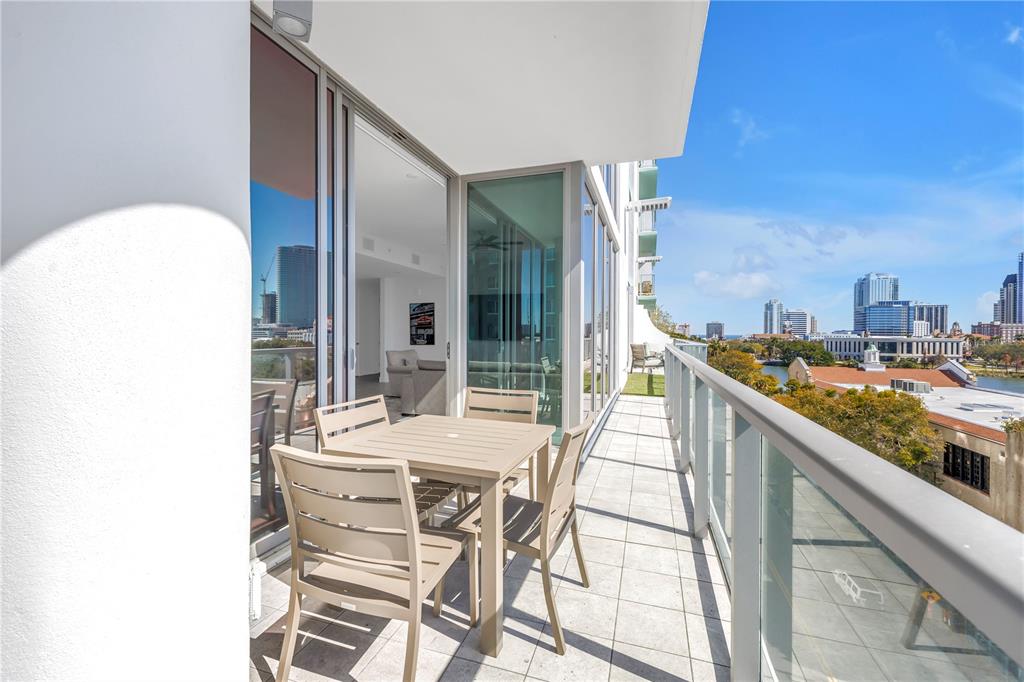 A balcony with outdoor furniture overlooks a city skyline and a body of water — 777 3RD AVENUE N UNIT 708, ST PETERSBURG, FL