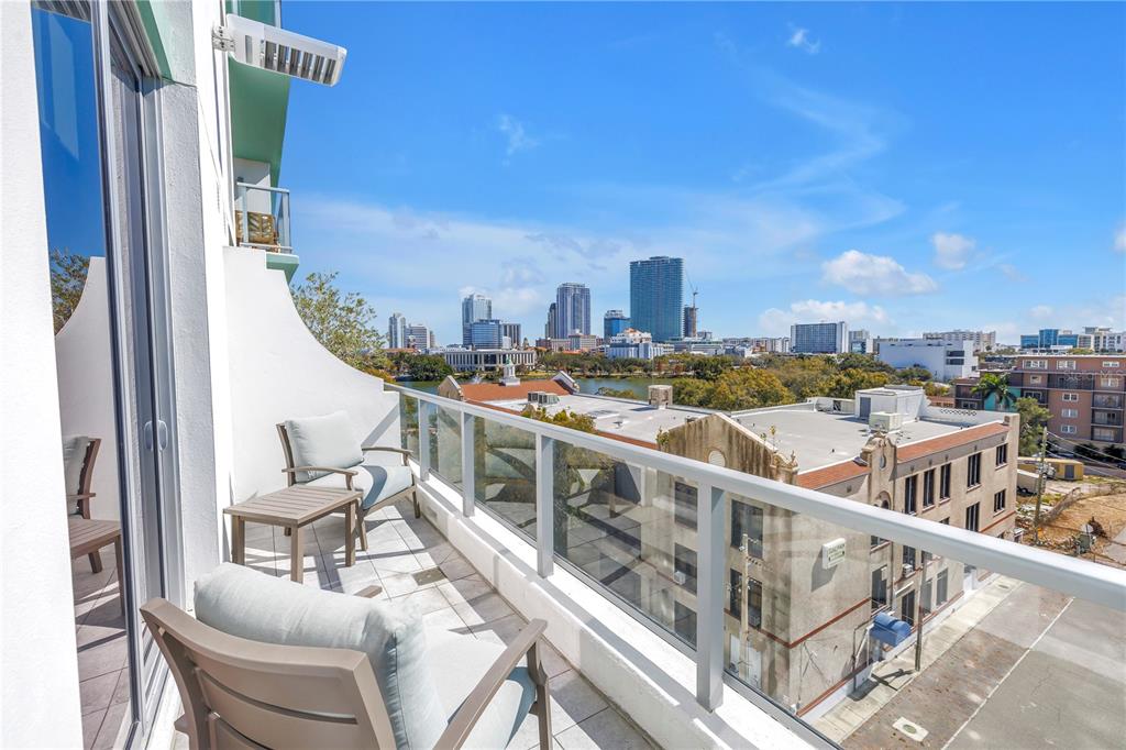 A balcony with two chairs overlooks a city skyline and a lake — 777 3RD AVENUE N UNIT 708, ST PETERSBURG, FL