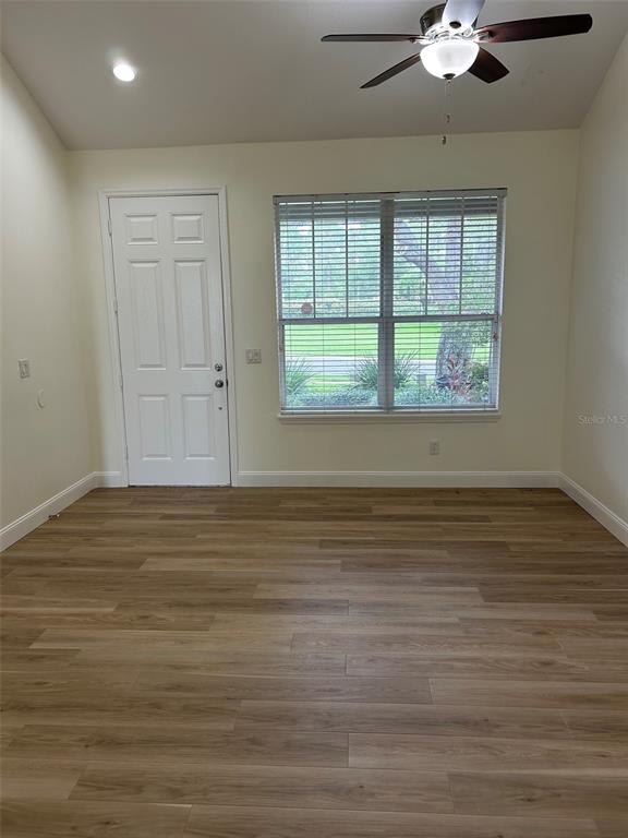 A room with light wood-look flooring, a white door, and a window with blinds — 34322 TUSCANY AVENUE, SORRENTO, FL