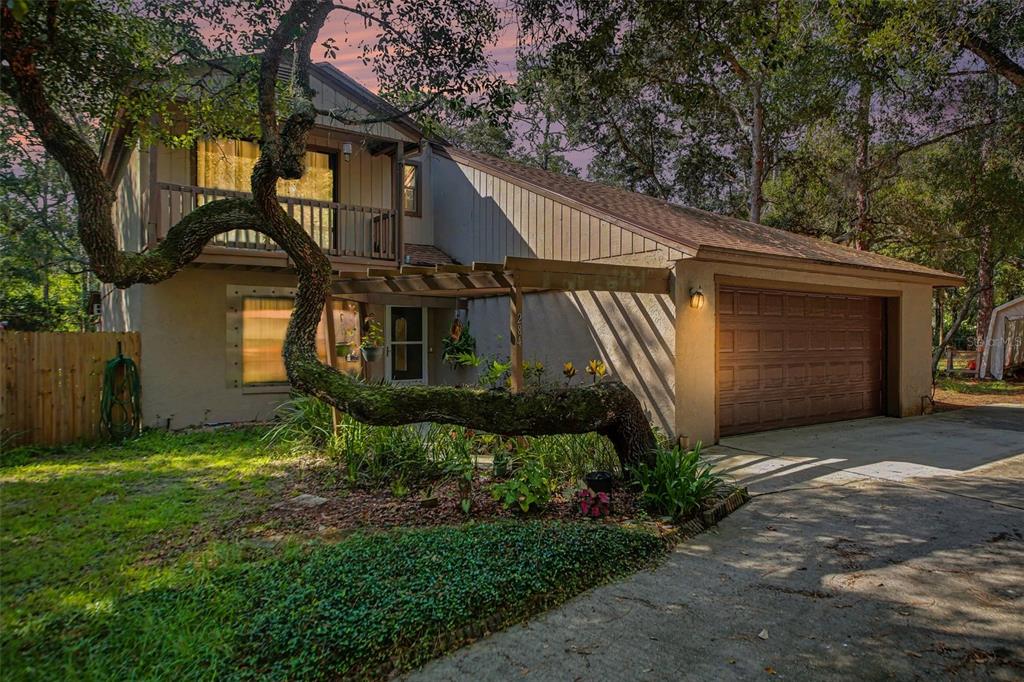 A two-story house with a wooden pergola, a garage, and a large tree in front — 284 CLEARVIEW ROAD, OVIEDO, FL