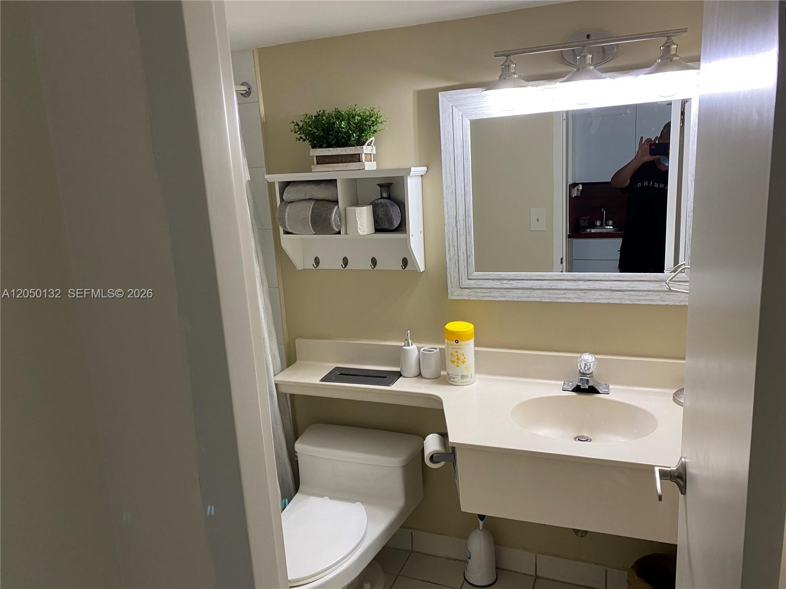 A bathroom features a vanity with a sink, a toilet, and a wall-mounted storage shelf — 19201 E Collins Ave # 442, Sunny Isles Beach FL 33160, SUNNY ISLES BEACH, FL