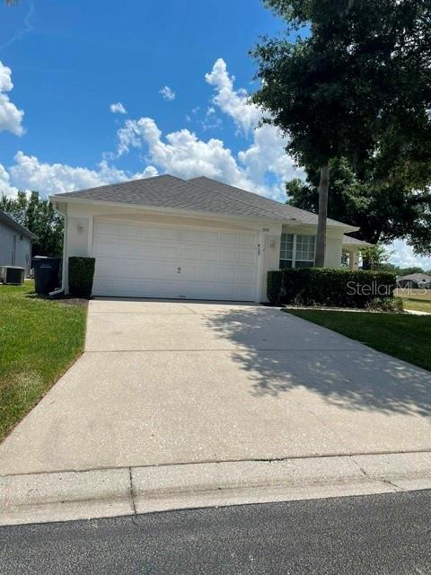 A single-story house with a white garage door and a concrete driveway under a blue sky — 1531 CASTERTON CIRCLE, DAVENPORT, FL