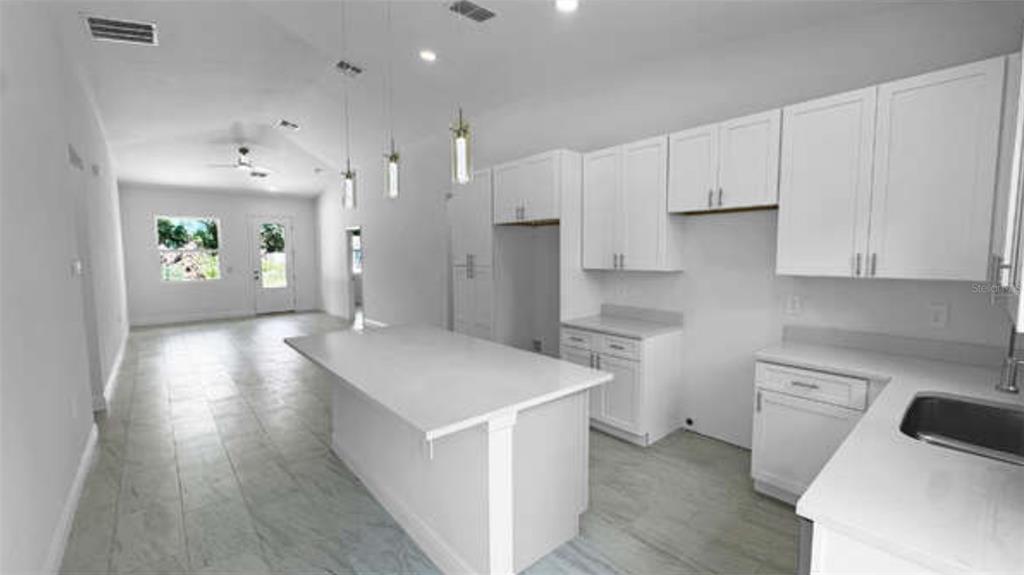 A modern living room features a sectional sofa, coffee table, television, and a ceiling fan — 3620 WASHINGTON STREET, SANFORD, FL