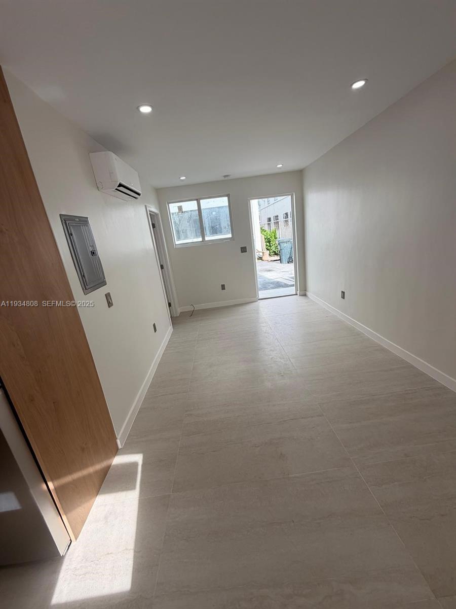 This room features light-colored tile flooring, white walls, a mini-split unit, and a doorway — 2436 SW 7th St # 9, Miami FL 33135, MIAMI, FL