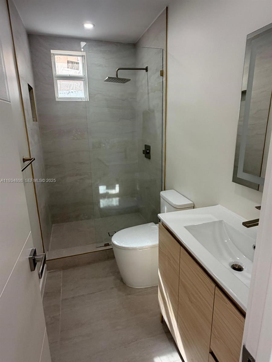 A modern bathroom features a glass-enclosed walk-in shower, a vanity, and a toilet — 2436 SW 7th St # 9, Miami FL 33135, MIAMI, FL