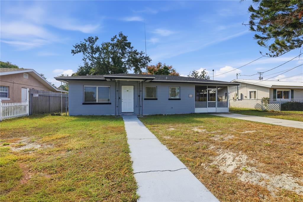 A single-story gray house with a white front door and a concrete walkway — 225 E POMELO STREET, LAKE ALFRED, FL