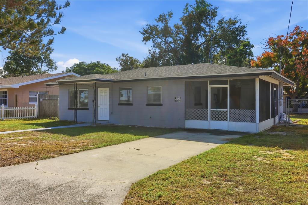 A single-story gray house with a concrete driveway and a screened-in front porch — 225 E POMELO STREET, LAKE ALFRED, FL