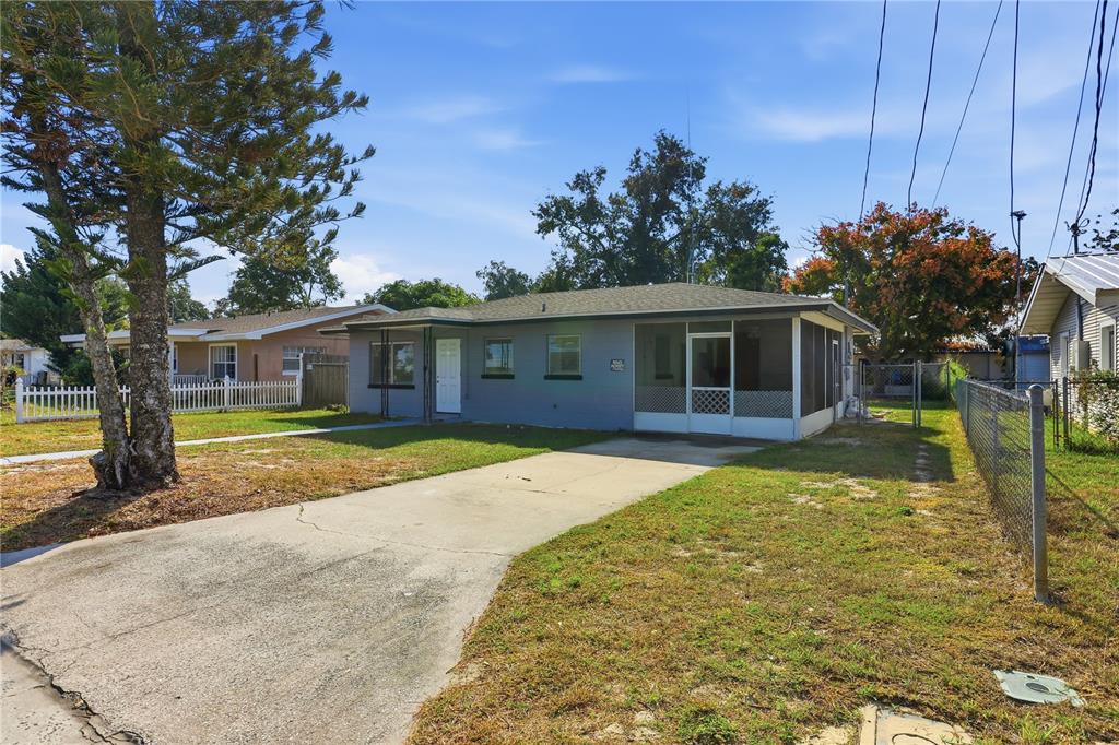 A single-story gray house with a concrete driveway and a screened-in front porch — 225 E POMELO STREET, LAKE ALFRED, FL