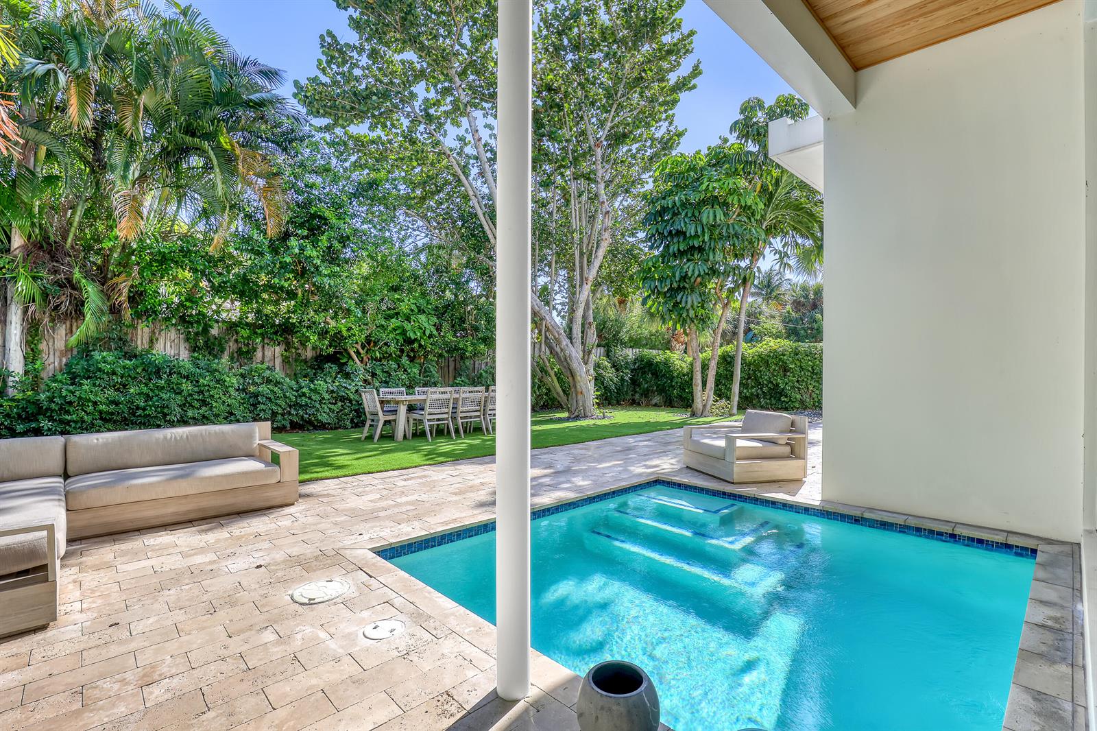 A patio features a small swimming pool, a sectional sofa, and a dining set outdoors — 703 NE 5th Street, Delray Beach FL 33483, DELRAY BEACH, FL