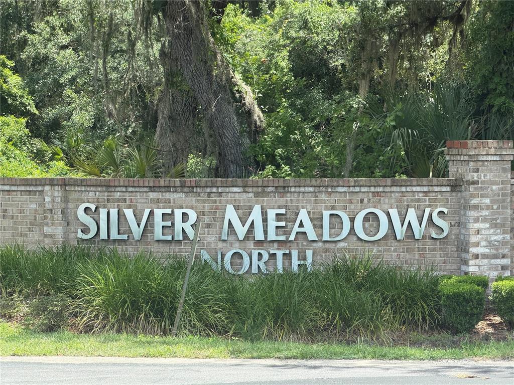 A brick sign for Silver Meadows North stands in front of trees and landscaping — 5967 NE 63RD STREET, SILVER SPRINGS, FL