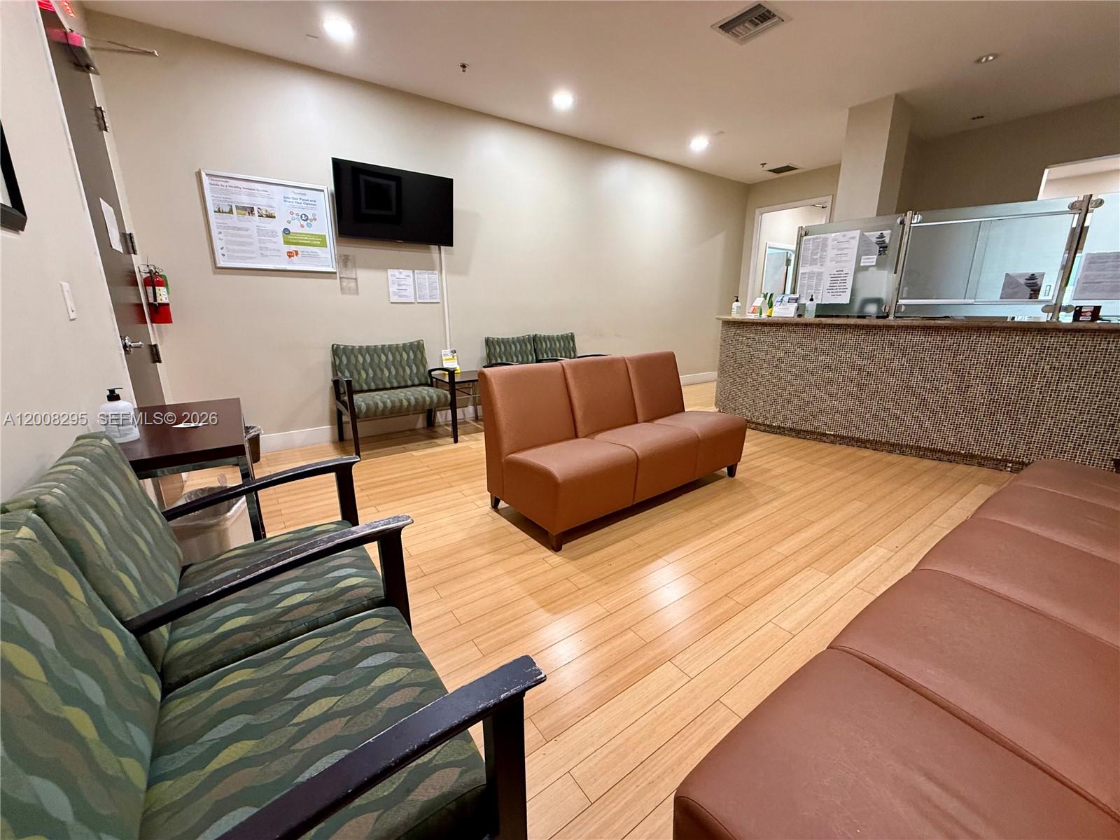 A waiting room features wood-look flooring, a reception desk, and various chairs for seating — 8501 SW 124th Ave # 112A, Miami FL 33183, MIAMI, FL