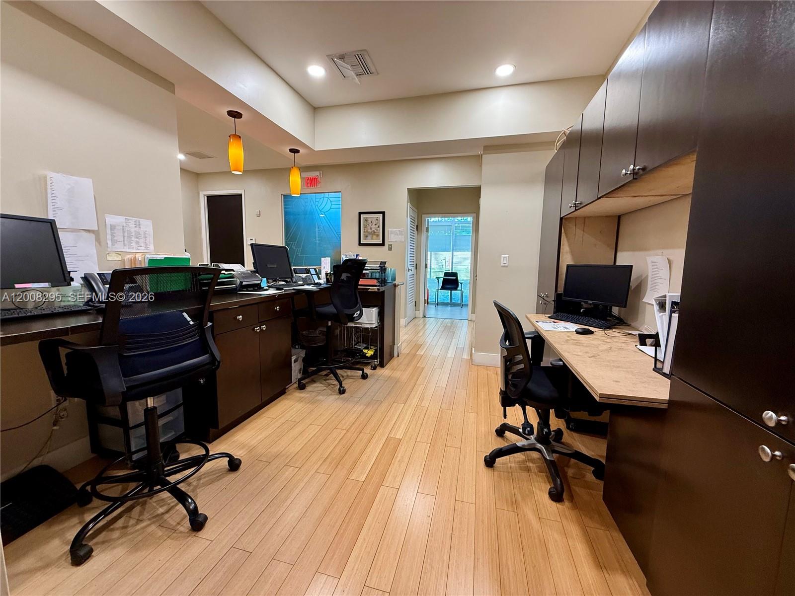 A home office features three computer workstations, dark cabinetry, and light wood flooring — 8501 SW 124th Ave # 112A, Miami FL 33183, MIAMI, FL