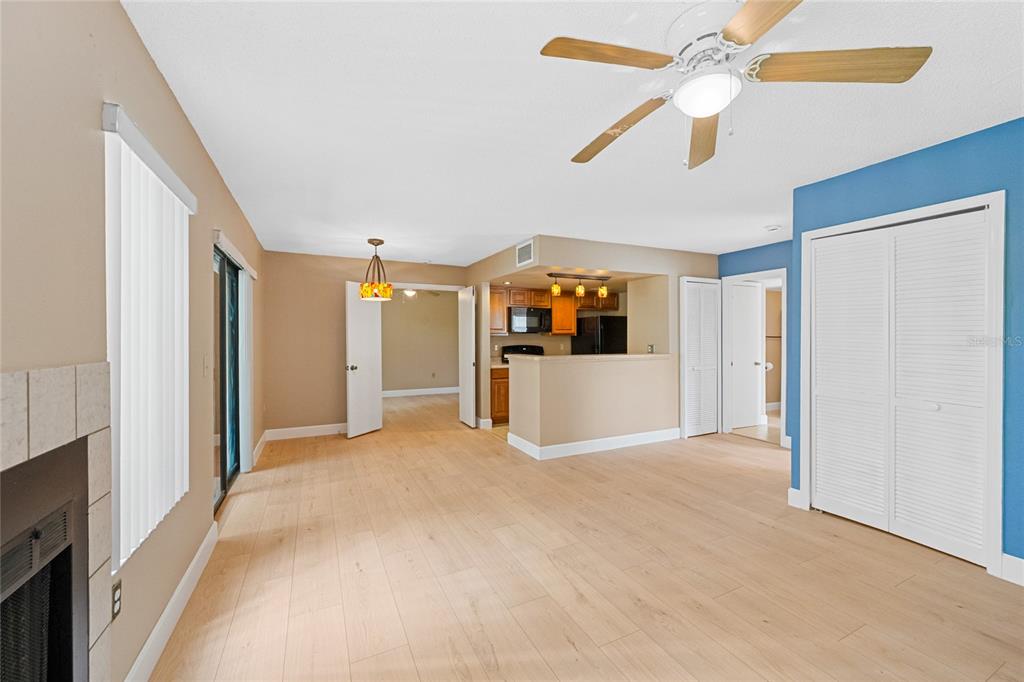 A living room with light wood flooring, a ceiling fan, and an open kitchen area — 543 SUN RIDGE PLACE UNIT 102, ALTAMONTE SPRINGS, FL