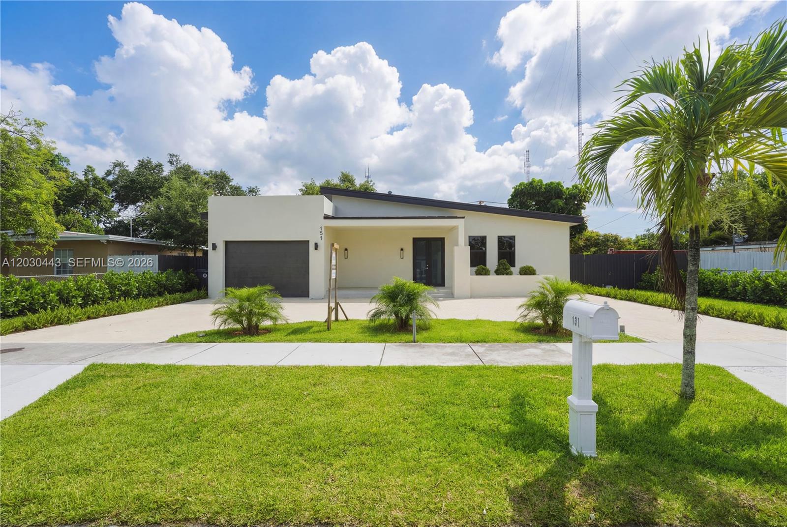 A modern, single-story house with a flat roof, garage, and a paved driveway — 131 Miami Gardens Rd, West Park FL 33023, WEST PARK, FL