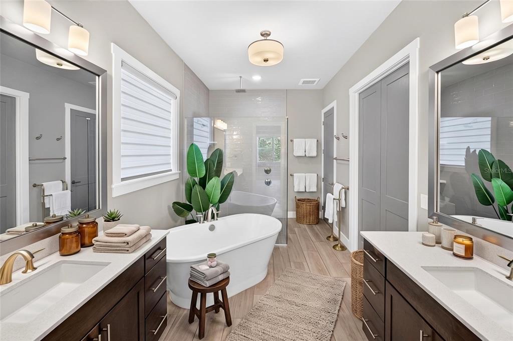 A modern bathroom features dual vanities, a freestanding soaking tub, and a glass-enclosed shower — 11872 SW 33RD LANE, GAINESVILLE, FL