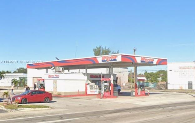 A red car is parked at a gas station with a white convenience store building — 14126 NW 27th Ave, Opa-Locka FL 33054, OPA-LOCKA, FL