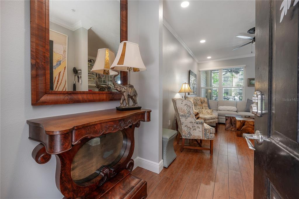 An entryway with a wooden console table and mirror leads into a living room area — 1810 E PALM AVENUE UNIT 4103, TAMPA, FL