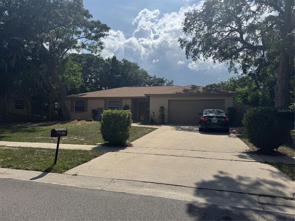 A single-story house with a concrete driveway, a two-car garage, and a front lawn — 1016 KIRK STREET, ORLANDO, FL