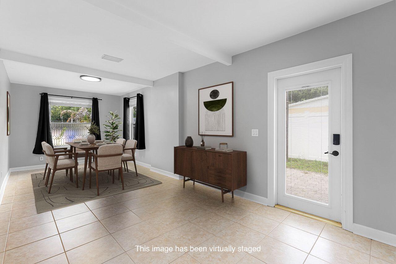This virtually staged dining room features light gray walls, tile flooring, and a wooden sideboard — 926 37th Avenue, Vero Beach FL 32960, VERO BEACH, FL