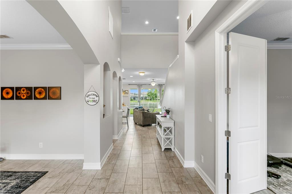 A view through a tiled entryway into a living area with high ceilings and windows — 10506 ALCON BLUE DRIVE, RIVERVIEW, FL