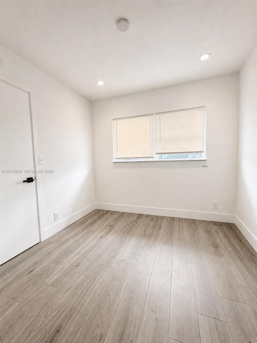 A small, empty room features white walls, light wood-look flooring, and a window with blinds — 612 NW 1st Ave # 00, Hallandale Beach FL 33009, HALLANDALE BEACH, FL
