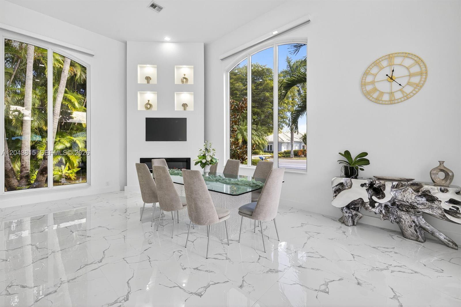 A dining room features a glass table, six chairs, marble floors, and a fireplace wall — 2673 NW 64th Blvd, Boca Raton FL 33496, BOCA RATON, FL