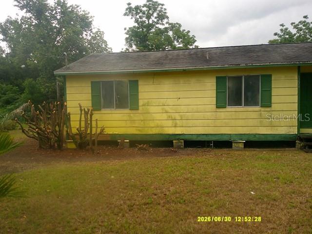 A yellow single-story house with a green door and a screened-in porch — 6229 TERRELL ROAD, MOUNT DORA, FL