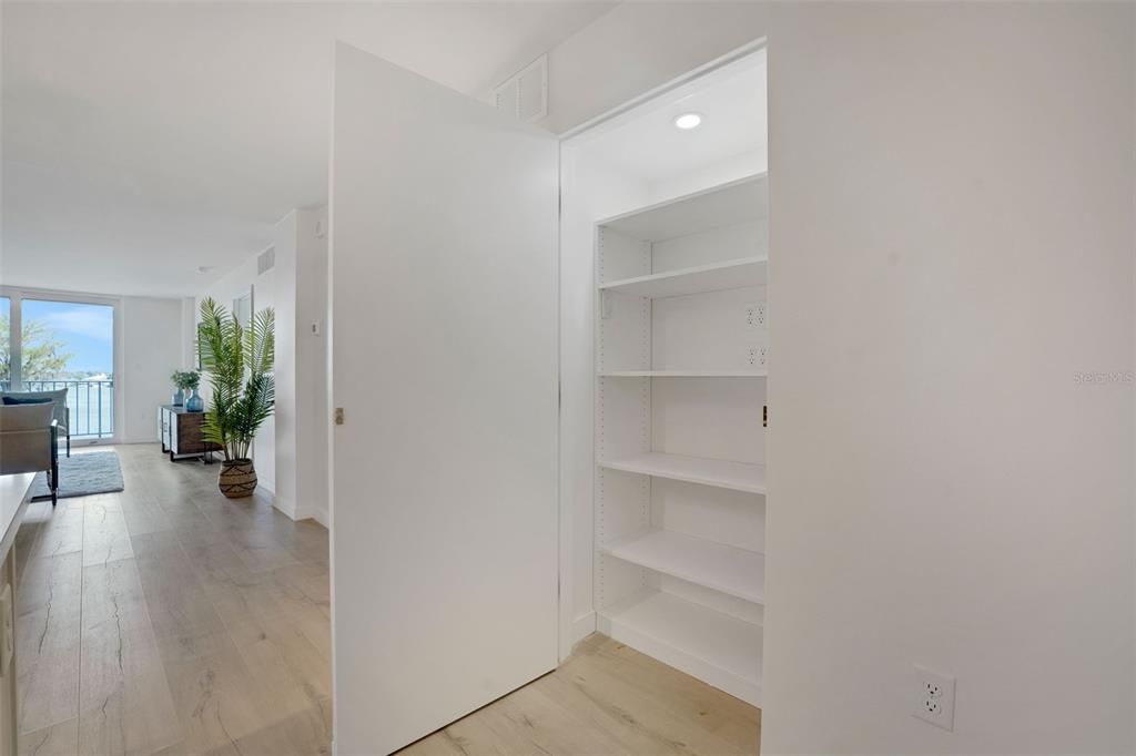 A white door opens to reveal a built-in shelving unit in a bright, modern room — 1100 S ORLANDO AVENUE UNIT 306, MAITLAND, FL