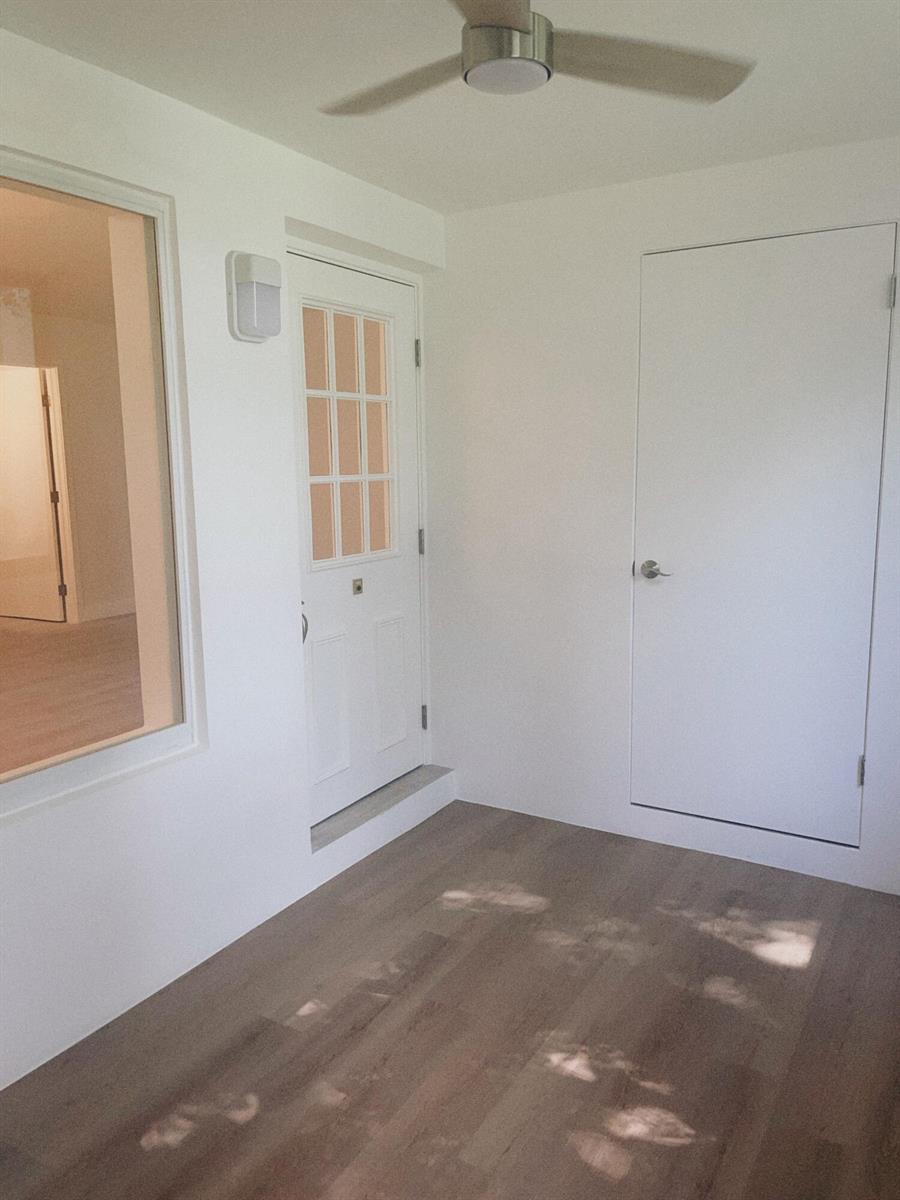 A bright entryway features light wood flooring, a white door with glass panes, and a ceiling fan — 5993 La Pinata Boulevard # D1, FL 33463, FL
