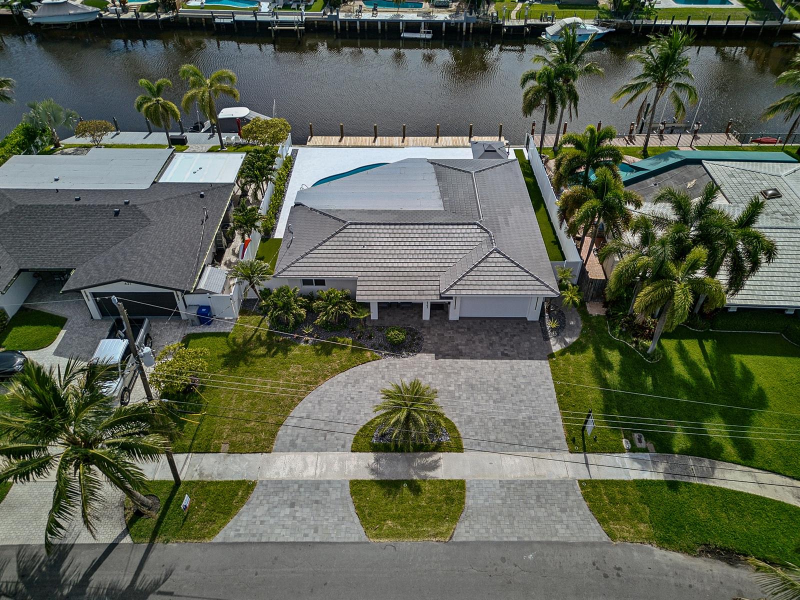 An aerial view shows a house with a gray tiled roof, pool, and paved driveway — 411 SE 2nd Avenue, Pompano Beach FL 33060, POMPANO BEACH, FL