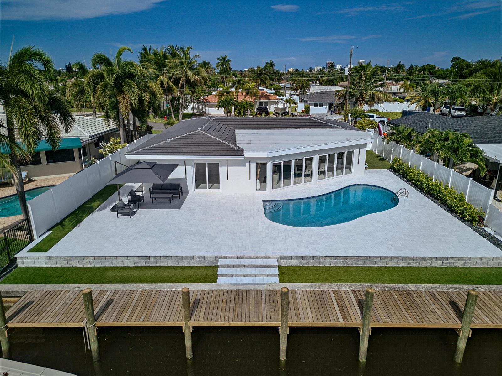 An aerial view of a white house with a pool, patio, and wooden dock — 411 SE 2nd Avenue, Pompano Beach FL 33060, POMPANO BEACH, FL