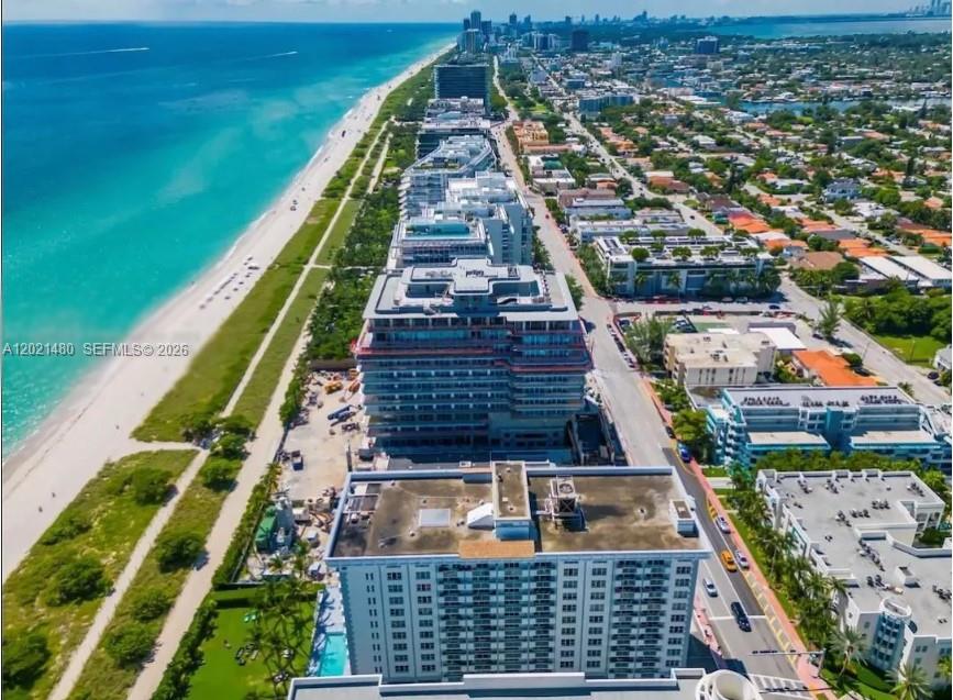 An aerial view shows a coastal city with high-rise buildings along a sandy beach — 9195 Collins Ave # 309, Surfside FL 33154, SURFSIDE, FL