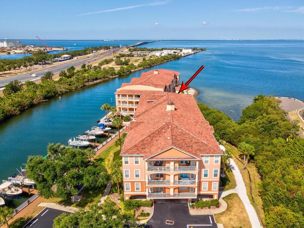 An aerial view shows a multi-story waterfront condominium building with a red tile roof — 5000 CULBREATH KEY WAY UNIT 9-116, TAMPA, FL
