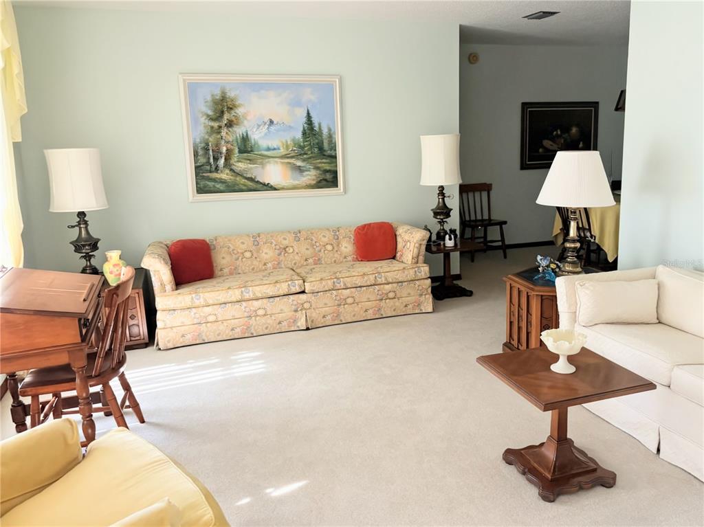 A living room features a floral sofa, a white sofa, and two wooden end tables — 20235 MAJESTIC STREET, ORLANDO, FL