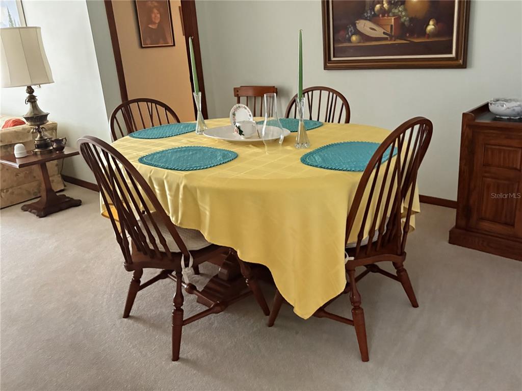 A dining room features a round table with a yellow tablecloth and four wooden chairs — 20235 MAJESTIC STREET, ORLANDO, FL