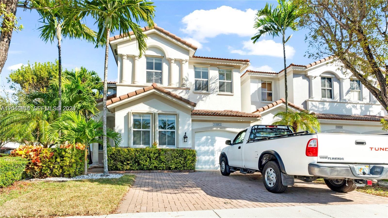 A two-story white stucco house with a tiled roof and a white pickup truck parked outside — 10863 NW 85th St # 0, Doral FL 33178, DORAL, FL