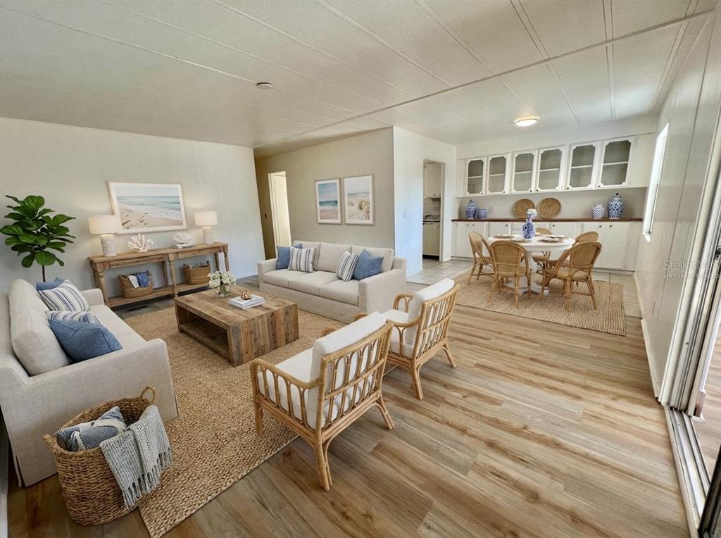 A bright living and dining area with light wood flooring, neutral furniture, and white cabinetry — 222 HAWTHORNE BOULEVARD, LEESBURG, FL